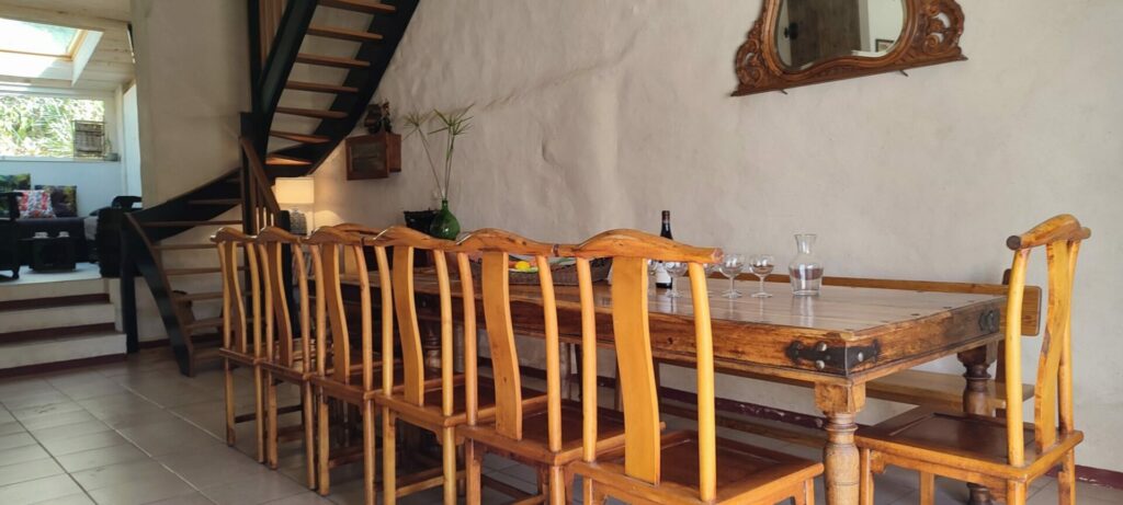 Grande table en bois dressée dans le séjour du gîte La Fenière, éclairée par un lustre ancien, ambiance festive, Le Pradet.