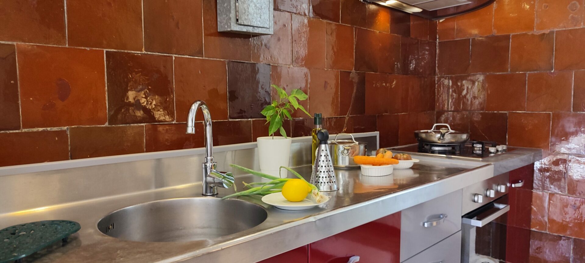 Vue d'ensemble de la cuisine professionnelle en inox du gîte La Fenière, avec évier et grand plan de travail, Le Pradet.