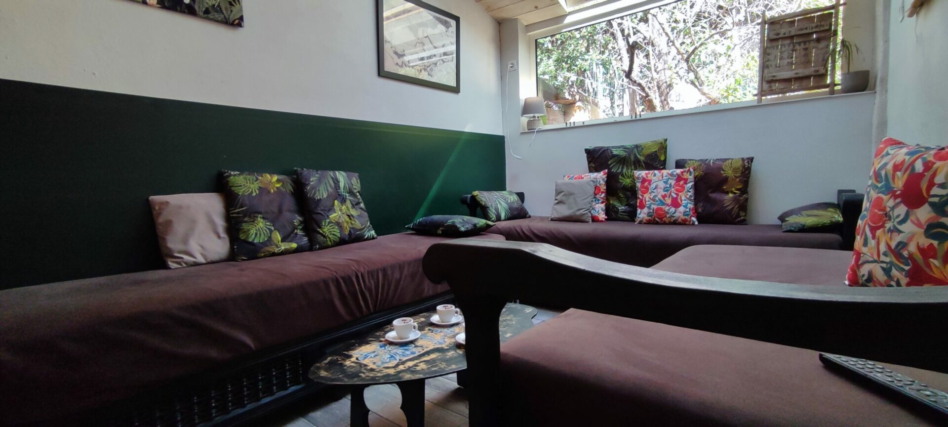 Salon cosy du gîte La Fenière avec table basse, banquettes marocaines confortables (sedari), ambiance lumineuse, Le Pradet.