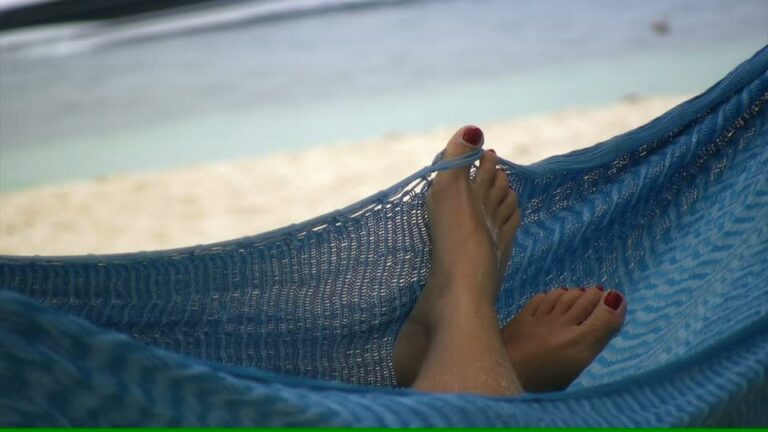 Jambes d'une femme se relaxant dans un hamac, ambiance de farniente, végétation méditerranéenne, symbolisant la quiétude et le slow tourisme au Mas de la Gavaresse, Le Pradet.