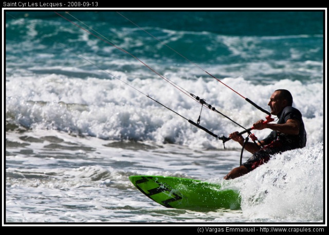 Kitesurfeur glissant sur l'eau tiré par une grande voile colorée, sport nautique, Méditerranée.