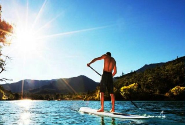 Personnes faisant du stand-up paddle sur une mer calme au lever ou coucher du soleil, activité de détente, Le Pradet.