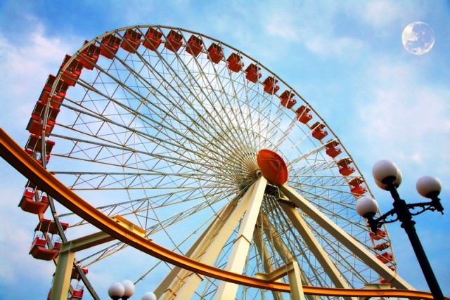 Montagnes russes et attractions d'un parc d'attractions avec des lumières vives la nuit, ambiance festive.