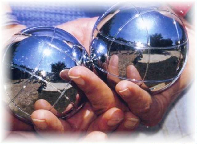Personnes jouant à la pétanque sur un terrain ombragé, ambiance conviviale provençale.