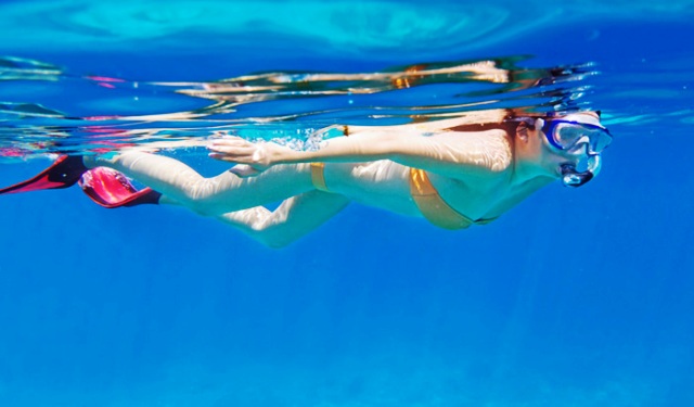 Enfant faisant du snorkeling avec masque et tuba dans une crique aux eaux claires, activité familiale, Le Pradet.