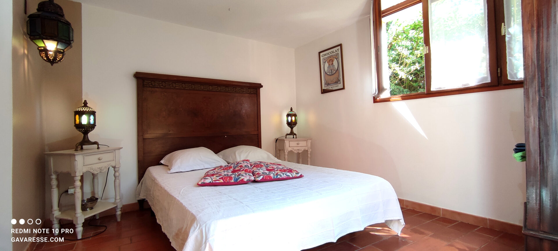 Chambre parentale gîte Le Pénéquet avec lit double 140x190, tête de lit sculptée, accès direct jardin, Le Pradet.