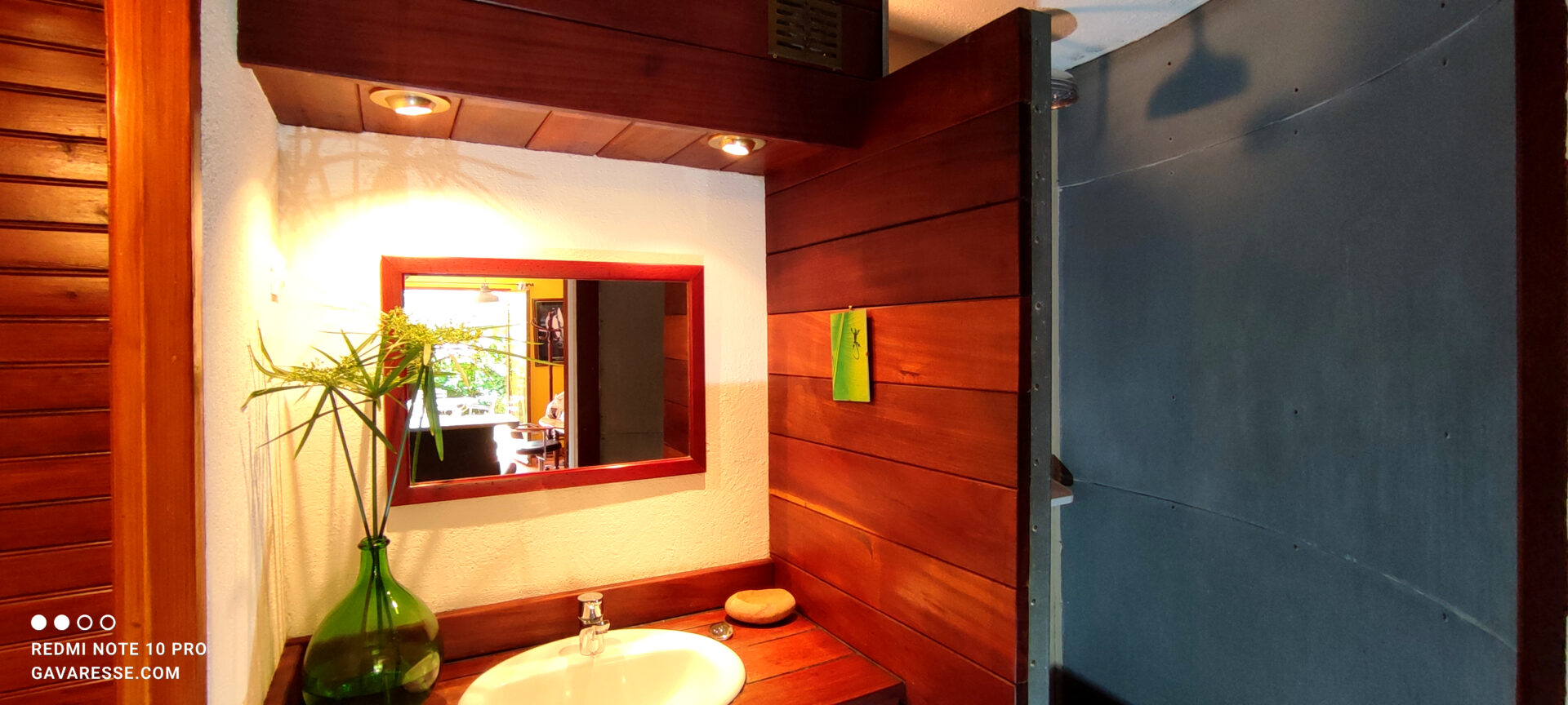 Salle de bain du gîte Le Pénéquet : douche à l'italienne parois zinc, pommeau arrosoir provençal, sol galets, Le Pradet.