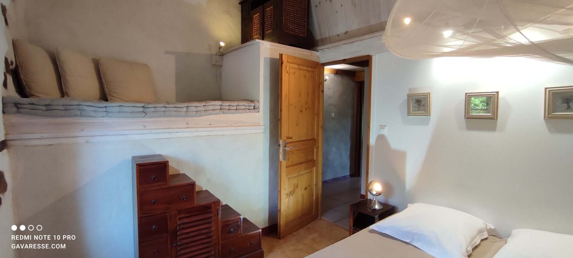 Banquette-lit en hauteur accessible par un meuble escalier dans la chambre de La Fenière, prête comme couchage ou coin lecture, Le Pradet.