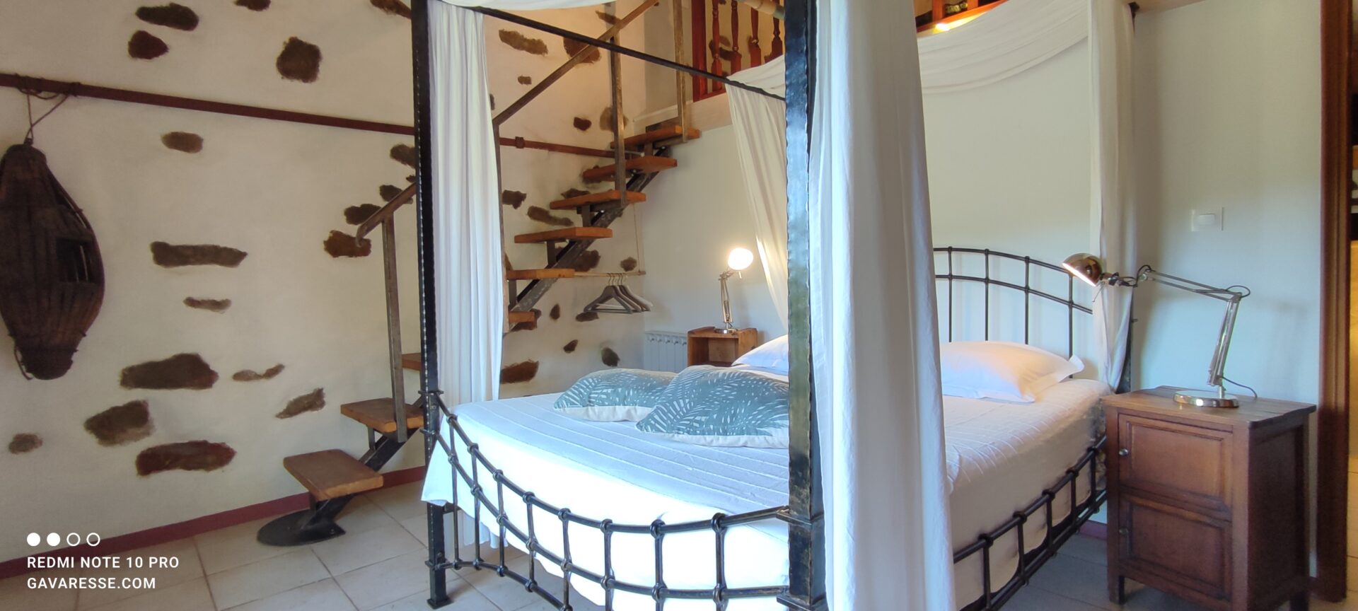 Vue d'ensemble de la chambre double parentale de La Fenière avec lit à baldaquin et accès à la mezzanine, Le Pradet.