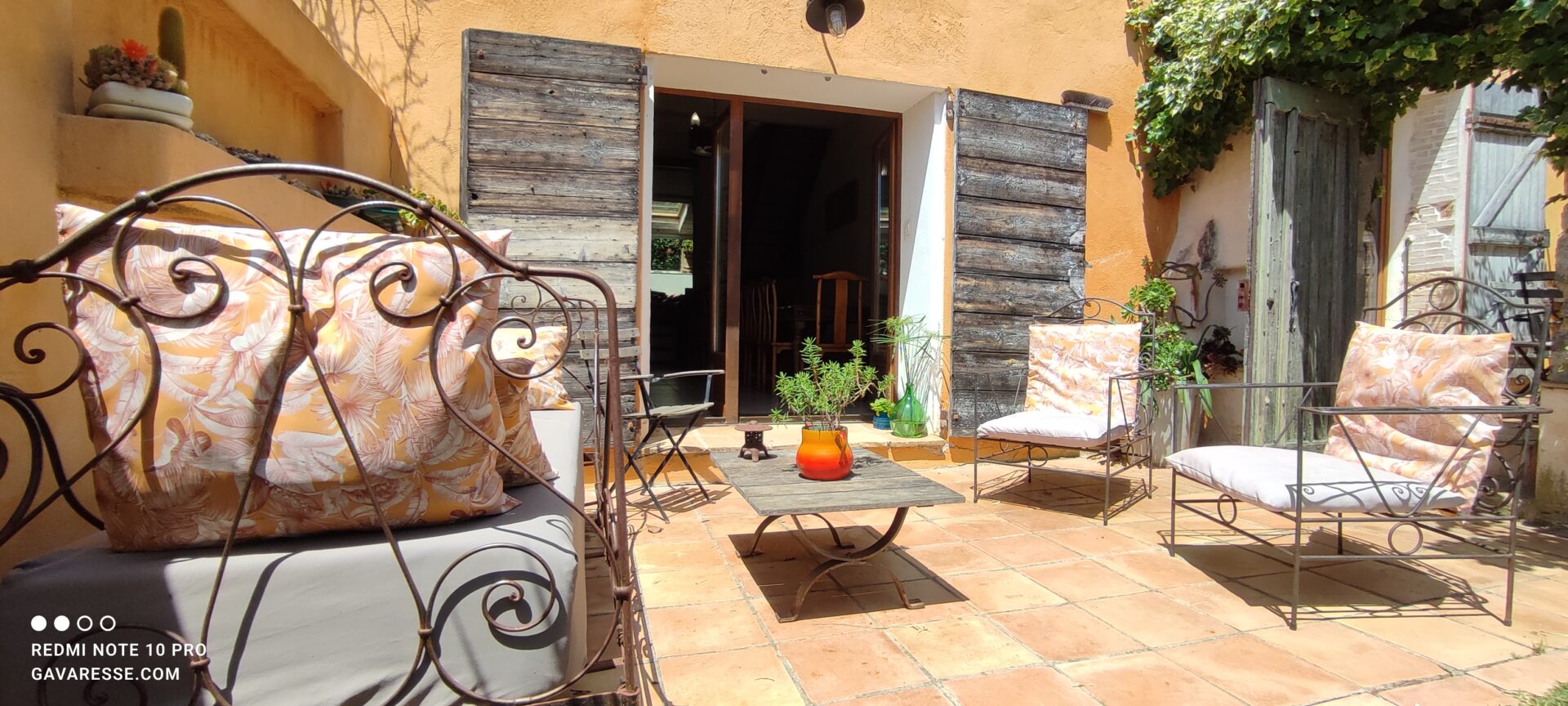Ancien lit en fer forgé reconverti en banquette extérieure sur la terrasse du gîte La Fenière, Le Pradet.