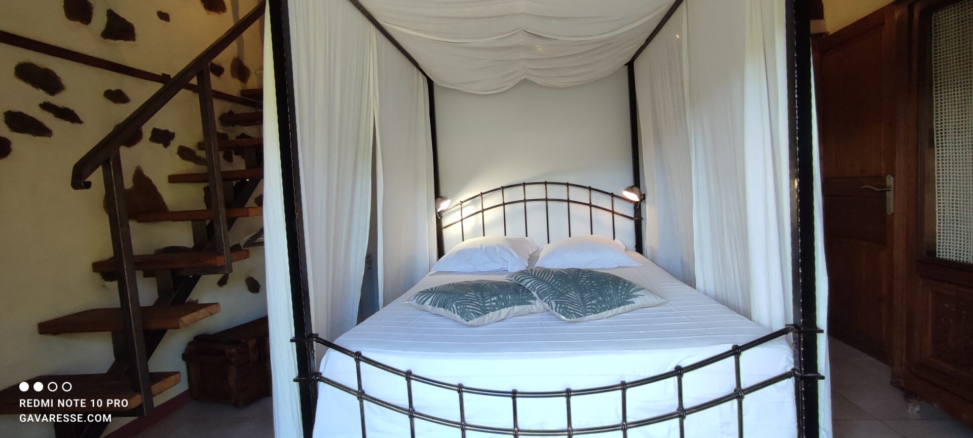 Lit à baldaquin fermé par des rideaux pour plus d'intimité dans la chambre parentale de La Fenière, Le Pradet.