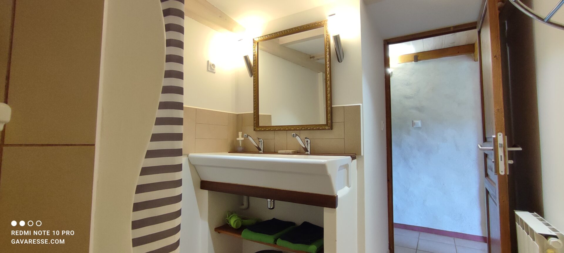 Grande vasque en pierre récupérée d'une ancienne école du Pradet dans la salle de bain de La Fenière, avec robinetterie moderne et miroir, Le Pradet.