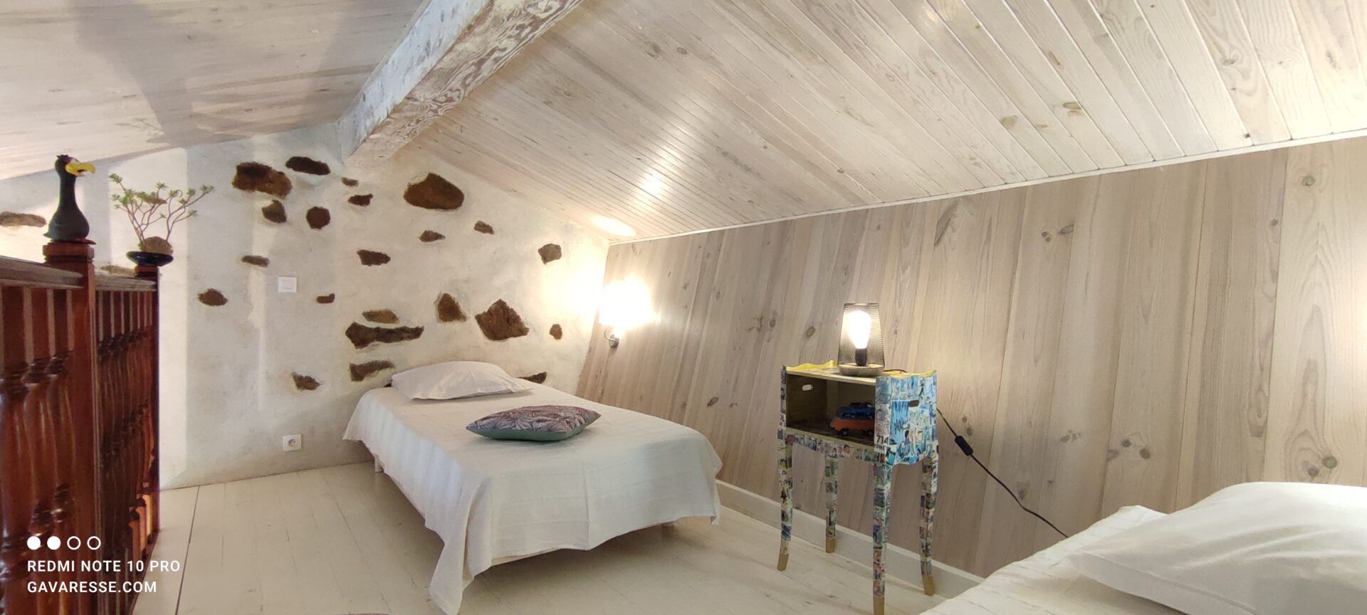 Table de nuit unique recouverte de planches de bande dessinée de Tintin, avec lampe et réveil, sur la mezzanine de La Fenière, Le Pradet.