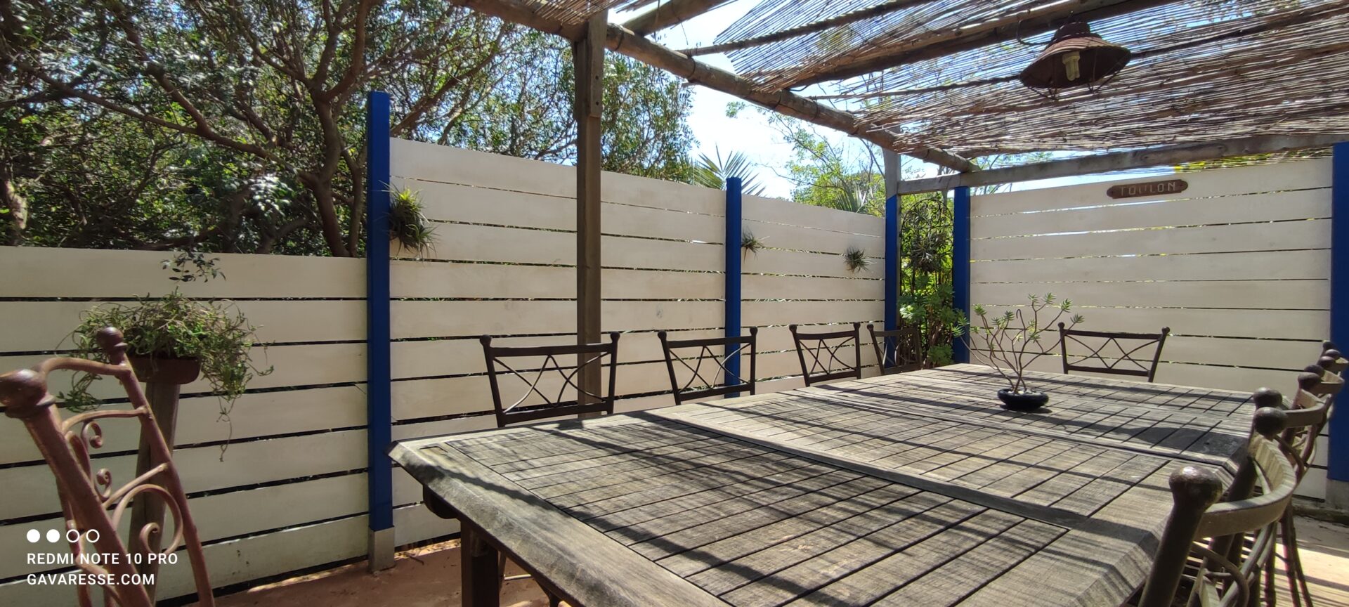 Grande terrasse ombragée par des canisses avec table à manger extérieure extensible pour 19 personnes, gîte La Fenière, Le Pradet.