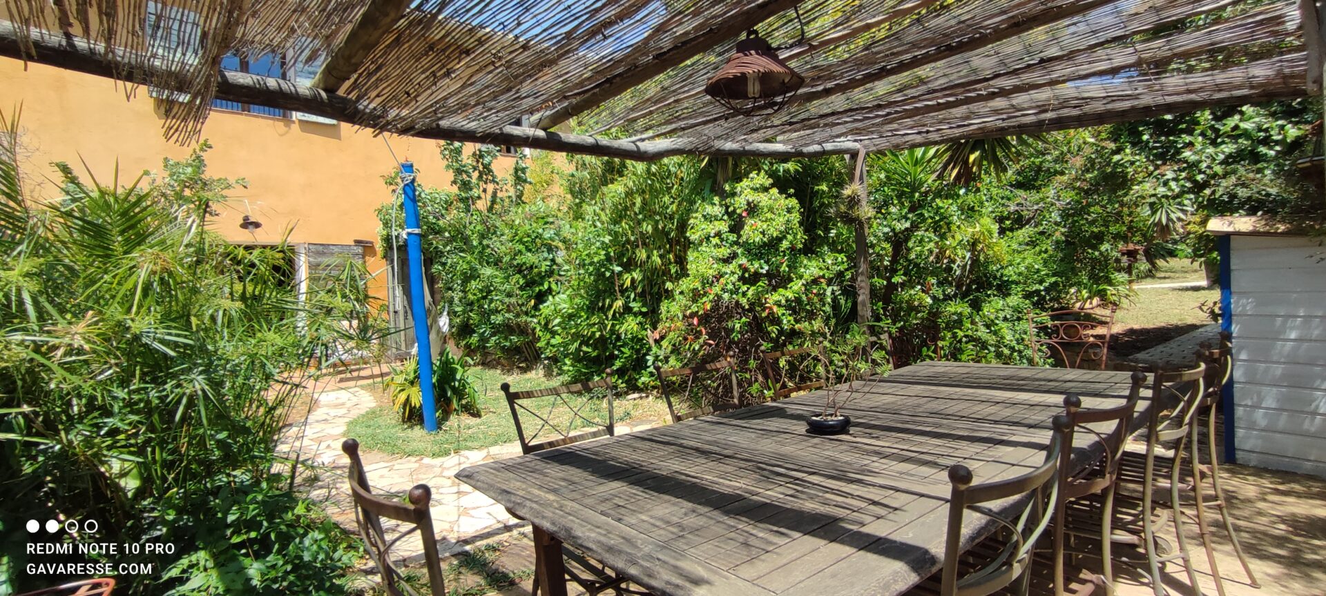 Terrasse ensoleillée du gîte La Fenière avec mobilier de jardin et accès à l'intérieur, Mas de la Gavaresse, Le Pradet.
