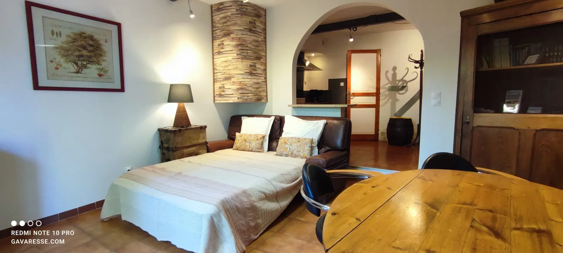 Canapé en cuir marron déplié en lit double (140x190 cm) avec draps clairs et coussins, situé dans le salon d'un grand gîte de vacances au Pradet, Var, près de la mer, offrant 2 couchages supplémentaires.